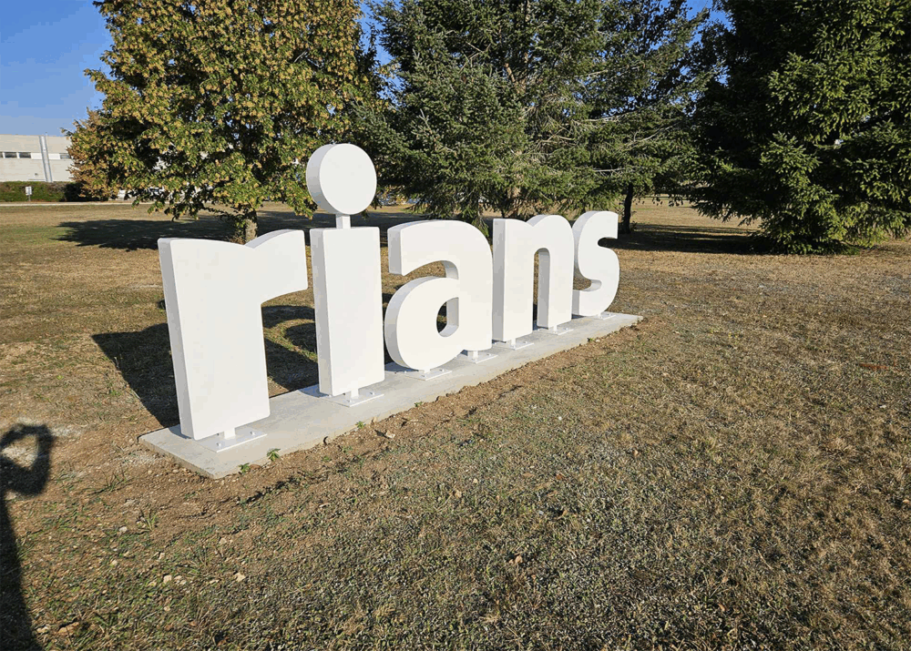 Enseigne monumentale en lettres 3D blanches du logo Rians installée en extérieur.